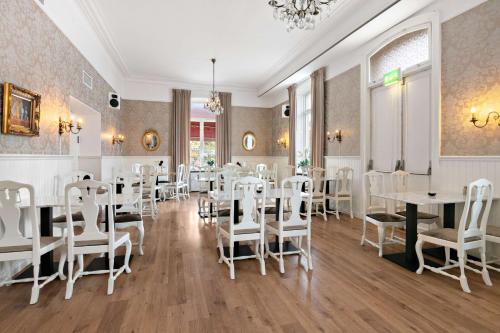 a dining room with white tables and chairs at Nora Stadshotell, Sure Hotel Collection by Best Western in Nora