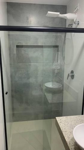 bagno con doccia in vetro e lavandino di Encanto da Vila a Morro de São Paulo