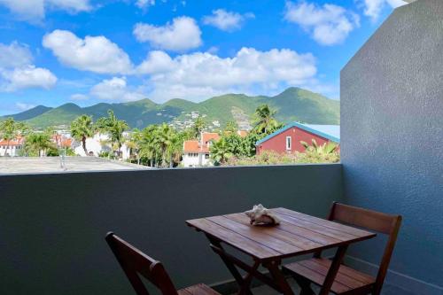 a table and chairs with a view of the mountains at 1 bedroom apt with pool in Simpson Bay in Koolbaai