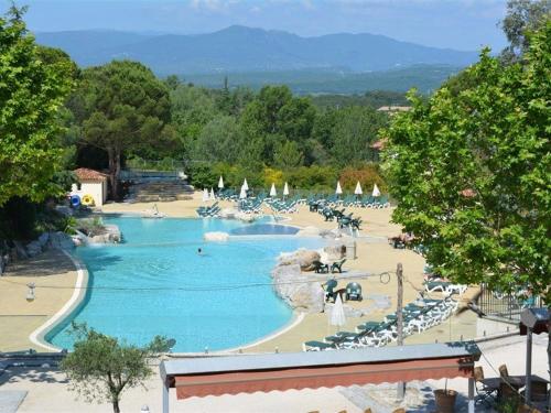 un complexe doté d'une piscine avec des chaises longues et des parasols dans l'établissement Maison climatisée 5 pers avec terrasse, parking, WiFi, et équipements complets dans quartier calme - FR-1-382-129, à Grospierres
