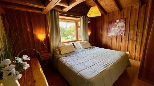 a bedroom with a bed in a wooden room at Las Nubes Cabañas in San Carlos de Bariloche