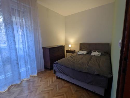 a bedroom with a bed and a dresser and a window at Deja FREE PARKING in Zvezdara