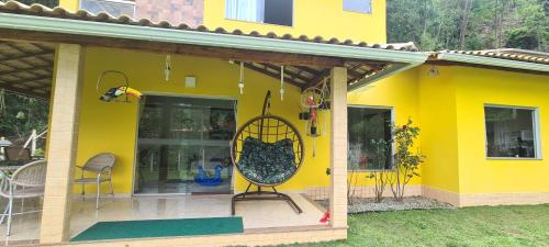 a yellow house with a front porch with a large mirror at Casa Amarela da Uruçu in Aracê