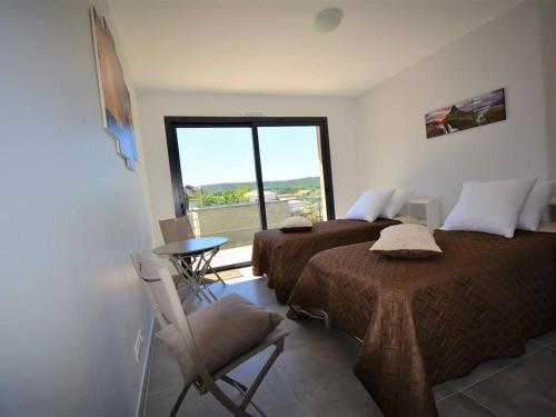 una camera da letto con due letti, un tavolo e una finestra di Villa 4 Suites avec Spa de Nage, Terrasse et Clim - Proche Centre Ruoms - FR-1-382-149 a Ruoms