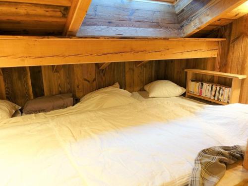 a large white bed in a wooden room at Chalet Arêches-Beaufort, 3 pièces, 4 personnes - FR-1-342-220 in Beaufort