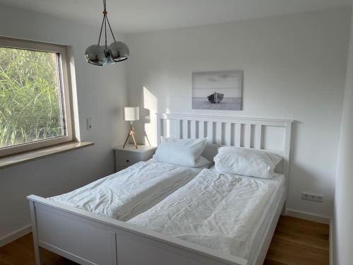 a white bed in a bedroom with a window at Ferien in Finning - im traumhaften Fünfseenland in Finning