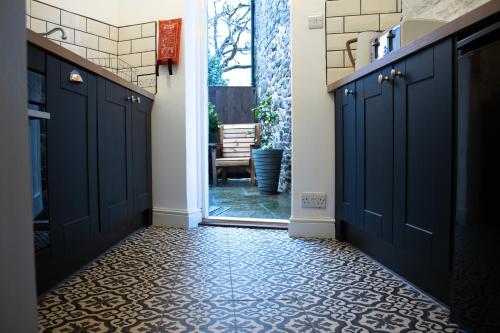 a hallway with blue cabinets and a tile floor at The Burrow in Kelso
