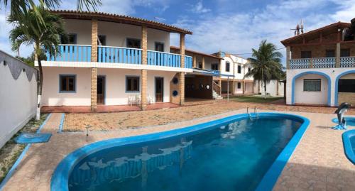 a villa with a swimming pool in front of a house at Recreio das Fontes in Beberibe