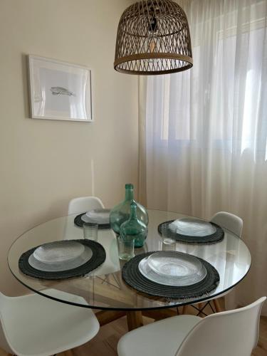 una mesa de comedor con platos y un jarrón. en Apartamento Córboba Centro en Córdoba