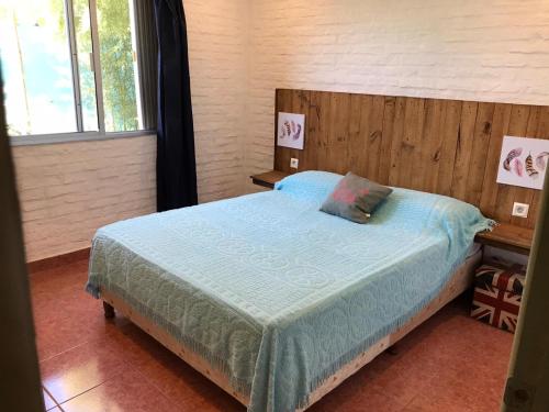 1 dormitorio con 1 cama con cabecero de madera en Complejo 421, en Piriápolis