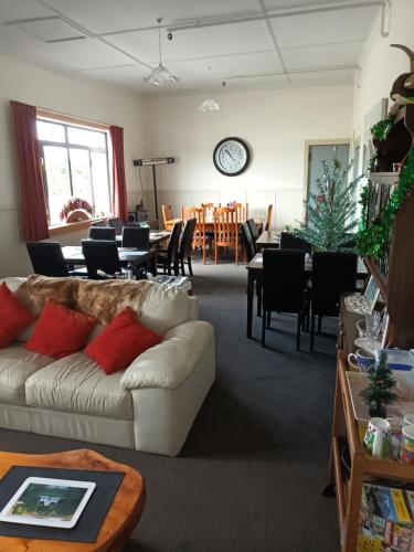 Ahaura Hotel في غرايموث: غرفة معيشة مع أريكة وغرفة طعام