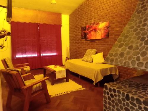 - une chambre avec un lit et un mur en briques dans l'établissement La Casa de la Parra, à Villa Carlos Paz