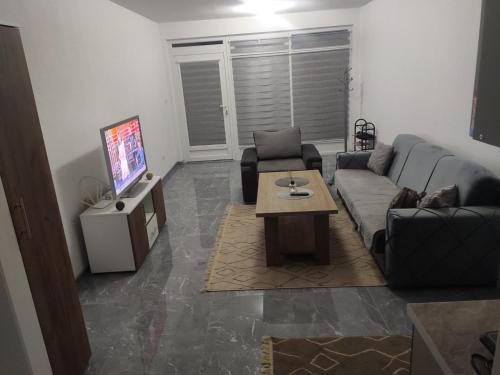 uma sala de estar com um sofá e uma mesa de centro em NEER em Živinice