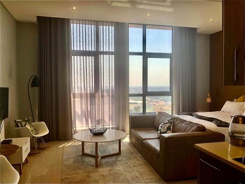 a living room with a couch and a large window at Urban Awe Apartment: iTowers 21st Floor in Gaborone