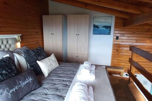 Habitación con cama en una cabaña de madera en Cabaña de montaña en Cerro Otto con increible Vista al Lago en San Carlos de Bariloche