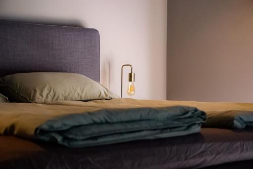 a bed with a blanket and a lamp on it at B&Bie ons in Bad-Nieuweschans