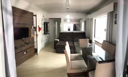 una pequeña sala de estar con sofá y TV en Apto no centro de Balneário com churrasqueira e estacionamento gratuito, en Balneário Camboriú