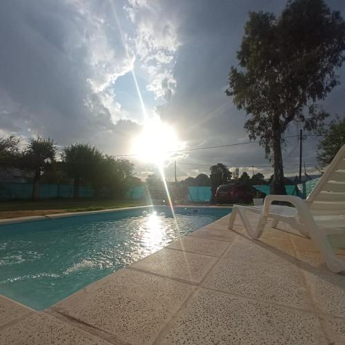 una silla blanca sentada junto a una piscina en El Abuelo en Santa Rosa de Calamuchita