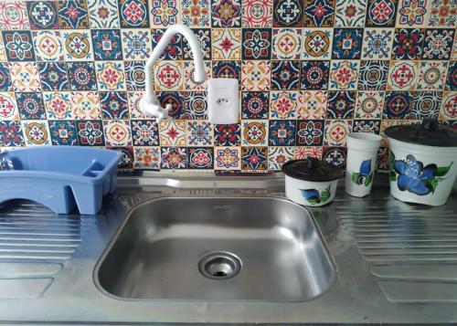 um balcão de cozinha com um lavatório e uma parede de azulejos em Loft/APTO em Praia da Pinheira em Pinheira