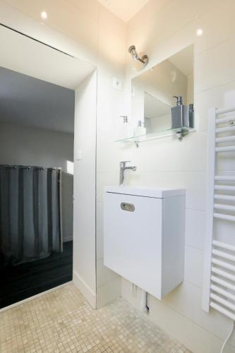 une salle de bain blanche avec un lavabo et une douche dans l'établissement Le 34 Malon, T5 hypercentre chic et cosy, wifi, netflix par SOVALFI, à Saint-Étienne