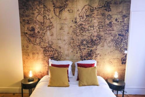 a bed with two pillows in front of a map wall at Le 34 Malon, T5 hypercentre chic et cosy, wifi, netflix par SOVALFI in Saint-Étienne