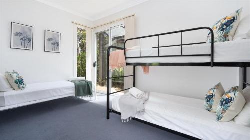 two bunk beds in a room with a window at Jervis Shores in Callala Bay