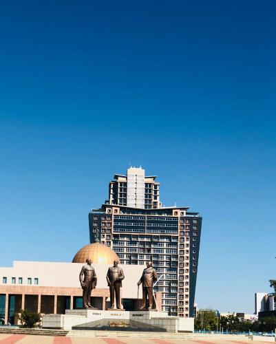 a statue of three men in front of a building at Urban Awe Apartment: iTowers 21st Floor in Gaborone