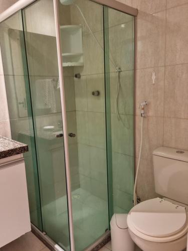 a bathroom with a glass shower with a toilet at BOA VIAGEM FLAT 106 in Recife