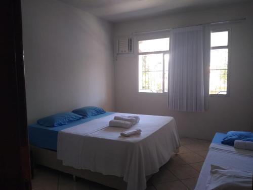ein Schlafzimmer mit einem Bett, auf dem Handtücher liegen in der Unterkunft Kitnet Itapuã in Vila Velha