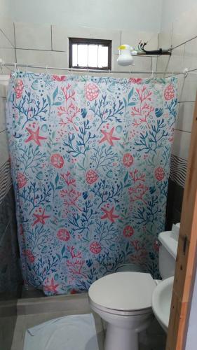 a bathroom with a flowered shower curtain with a toilet at Hotel Pacuare Turrialba in Turrialba