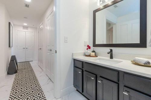 La salle de bains blanche est pourvue d'un lavabo et d'un miroir. dans l'établissement Lujoso departamento 3 bdrm, à Kissimmee