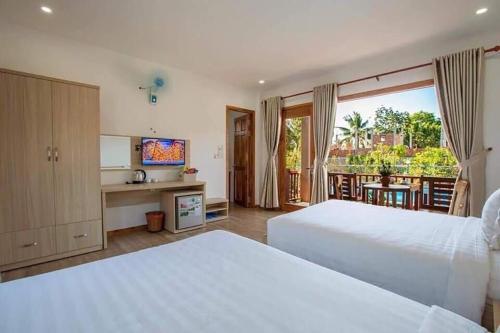 a hotel room with two beds and a balcony at Mộc Lam Bungalow Phú Quốc in Phú Quốc