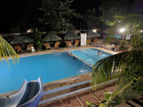ein großer Swimmingpool in der Nacht mit Menschen darin in der Unterkunft YSIDORE'S GARDEN in Roxas