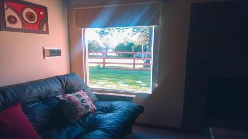 a blue leather couch in a room with a window at Pinares del Norte in Federación