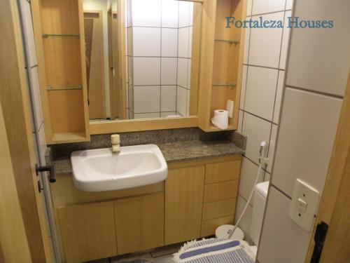 a small bathroom with a sink and a toilet at Porto de Iracema - Fortaleza houses in Fortaleza