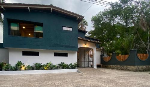una casa azul y blanca con garaje en Hostal Casa Mosaiko Patio Bonito Poblado en Medellín