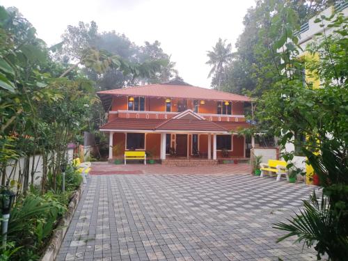 a house with a brick driveway in front of it at Quality Inn Varkala in Varkala