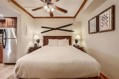 a bedroom with a white bed and a ceiling fan at Beaver Run Studio- Dog Friendly in Breckenridge
