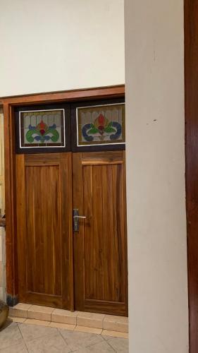 drewniane drzwi z witrażami w obiekcie Dona Homestay w mieście Yogyakarta