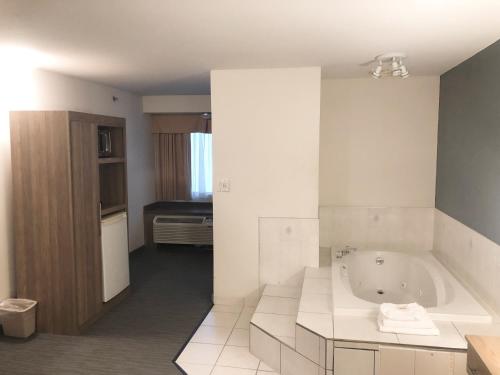 a white bathroom with a tub and a sink at Days Inn by Wyndham Niagara Falls Centre St By the Falls in Niagara Falls