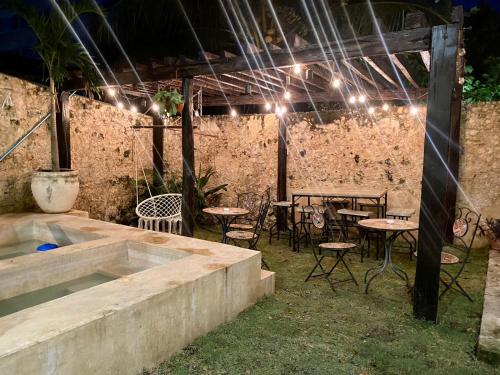 un patio al aire libre con mesas, sillas y luces en hotel xucum en Campeche