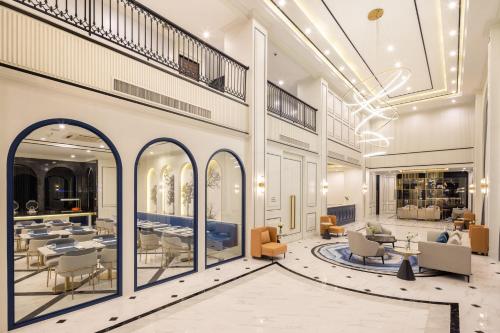 a lobby of a building with tables and chairs at Eastin Hotel Vientiane in Vientiane