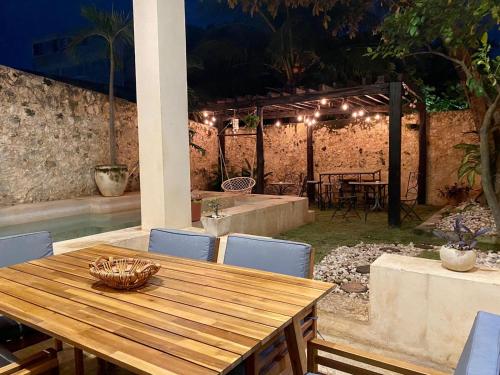 una mesa de madera y sillas en un patio en hotel xucum en Campeche