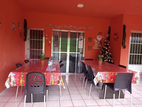 een eetkamer met 2 tafels en een kerstboom bij Pousada da Sônia in Camaragibe