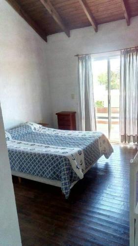 1 dormitorio con 1 cama con manta azul y blanca en Las moras en Chascomús
