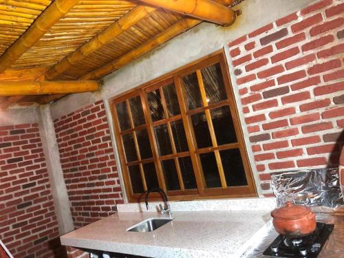 a kitchen with a sink and a brick wall at Casa - El Arrecife in Engabao