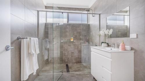 La salle de bains est pourvue d'une douche et d'un lavabo. dans l'établissement Surf Views on Northpoint, à Kiama Downs