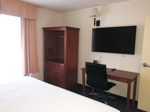 a hotel room with a bed and a desk and a television at Days Inn by Wyndham Niagara Falls Centre St By the Falls in Niagara Falls