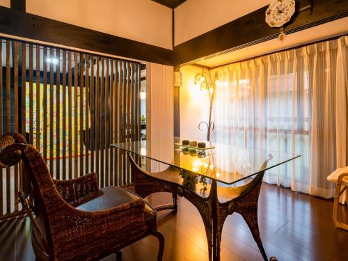 a dining room with a glass table and chairs at さいの郷「椛」 in Kagamino
