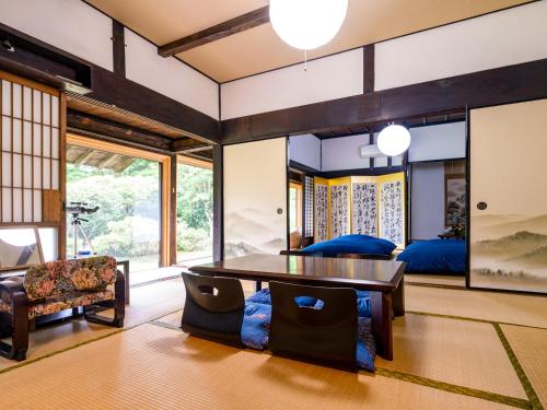 sala de estar con mesa y cama en さいの郷「椛」 en Kagamino